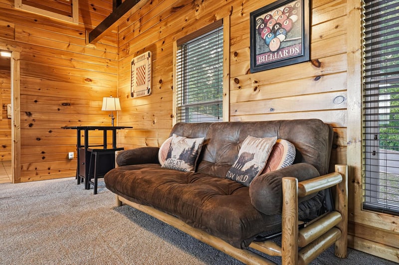 Unwind in this cozy cabin living room, where rustic wood walls and plush seating invite you to kick back and relax after a day of adventure.