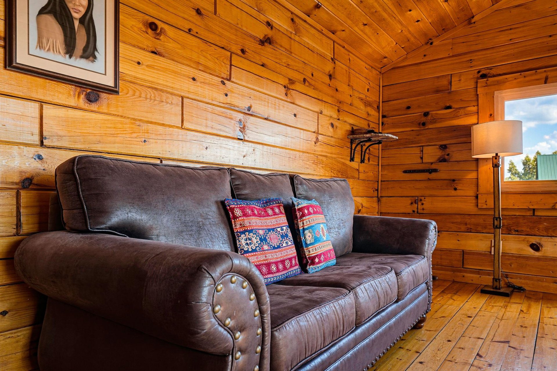 Sink into this plush leather sofa surrounded by warm knotty pine walls—your cozy retreat after a day of adventure.