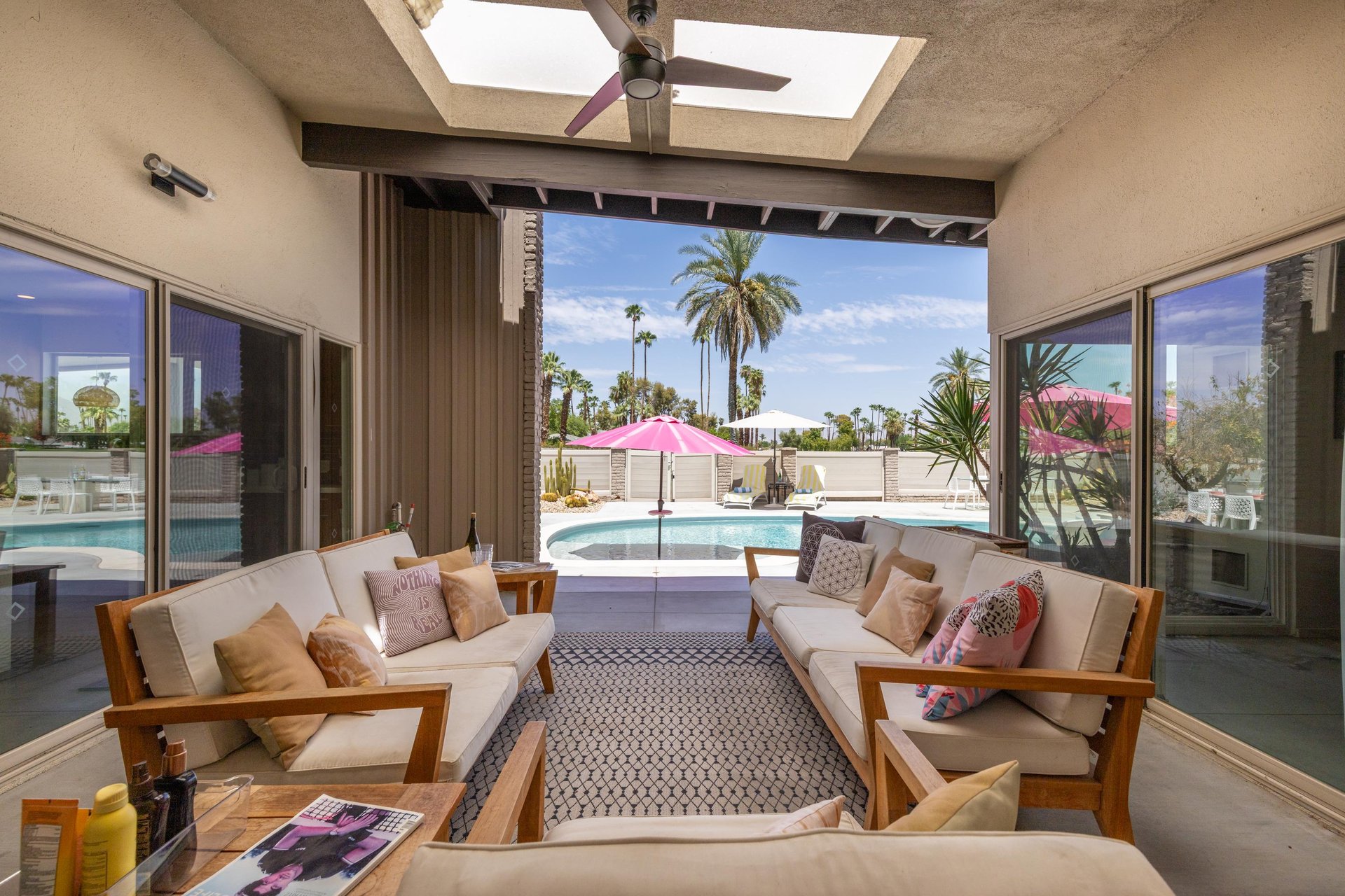 Covered patio just off of the living and dining space with outdoor seating, outdoor fan, and views of both the poolspa and golf course.