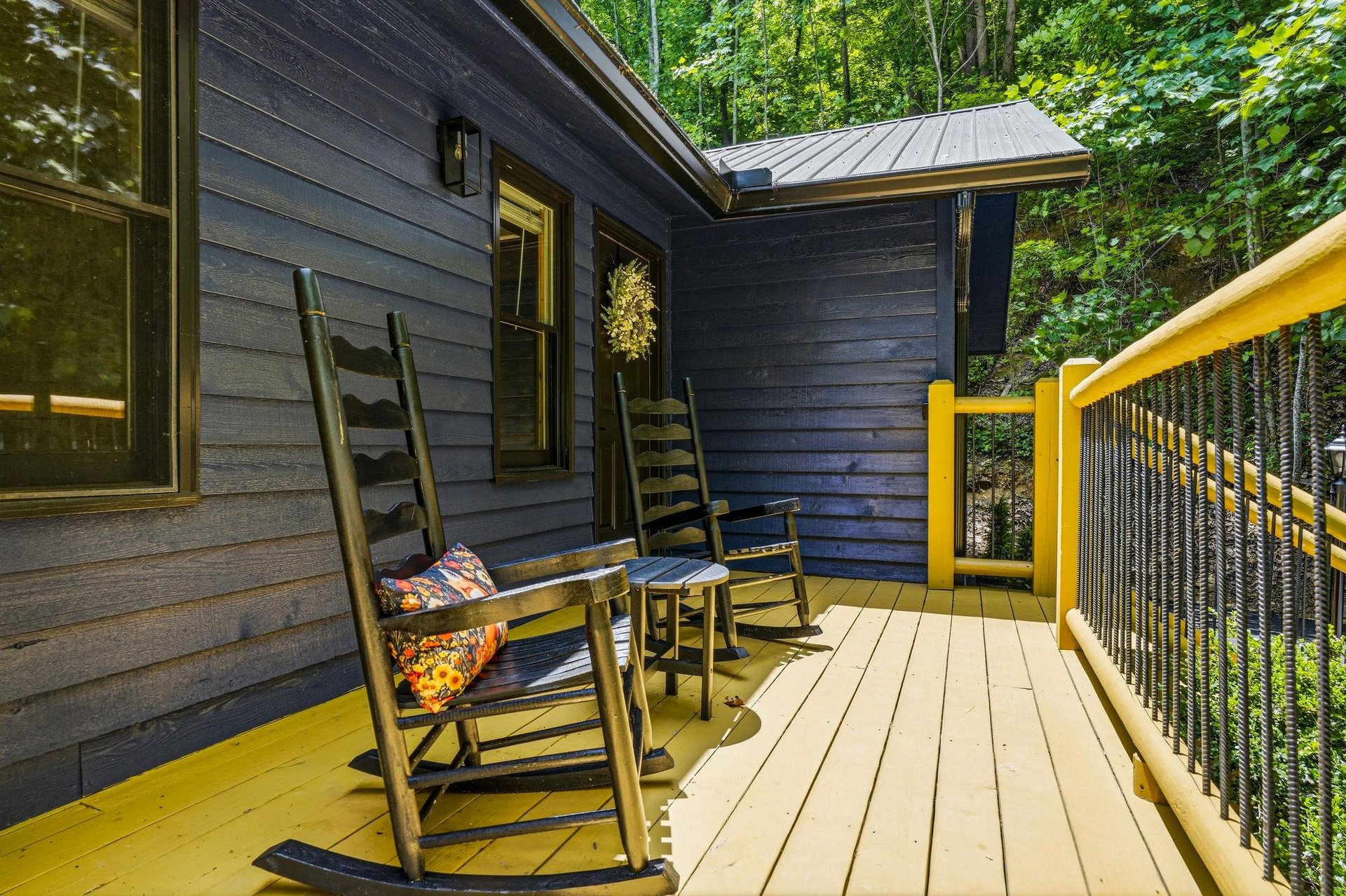 Relax on your private deck, where wooden rocking chairs and lush forest surroundings invite you to unwind with morning coffee or peaceful evening conversations.