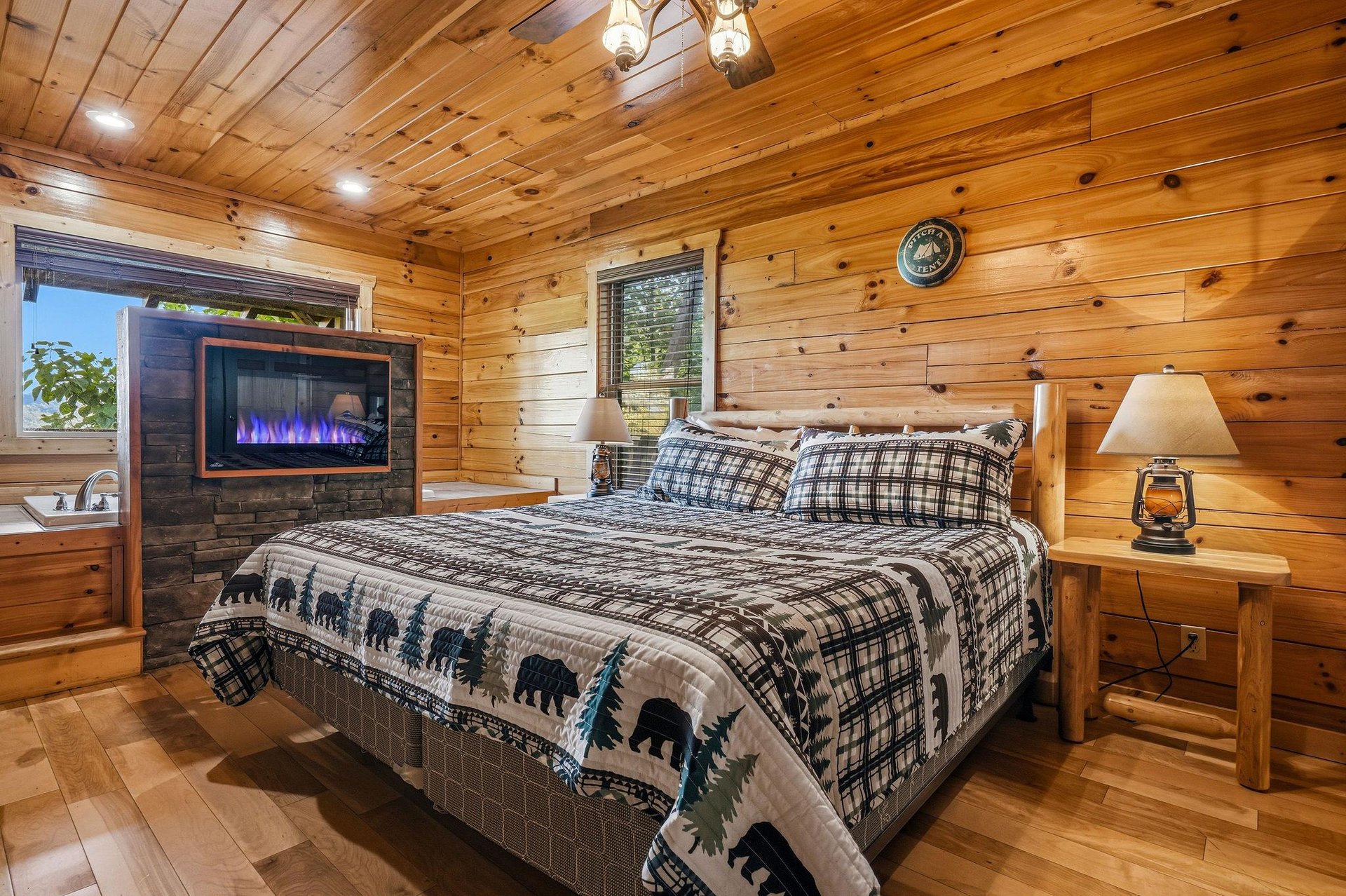 Snuggle into your cozy cabin bedroom, where rustic wood surrounds you and the gentle glow of the fireplace invites relaxation after a day of adventure.