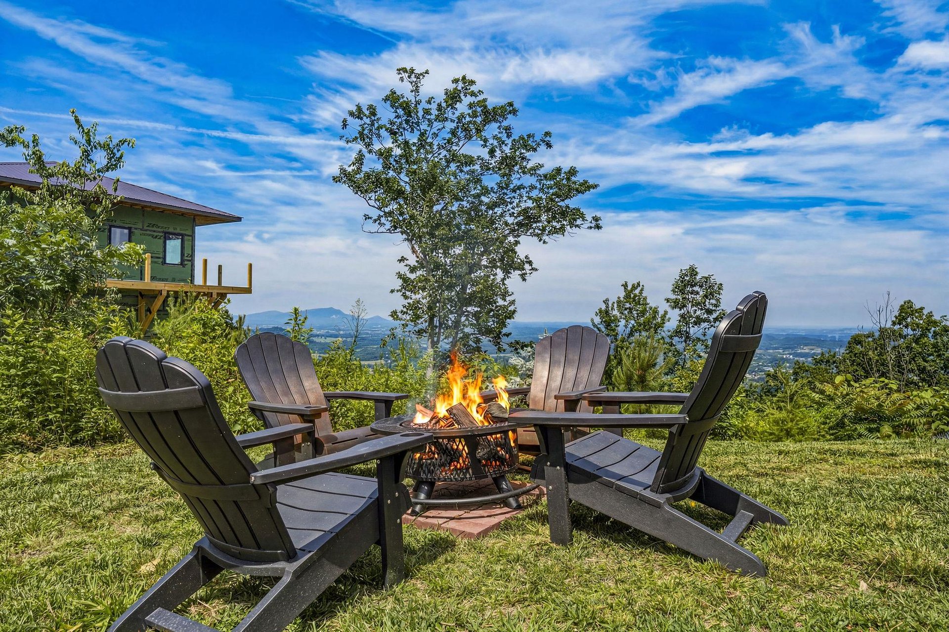 Stunning mountain panorama stretches across the horizon as you gather around the crackling fire pit, four Adirondack chairs inviting relaxed evenings under wideopen skies.