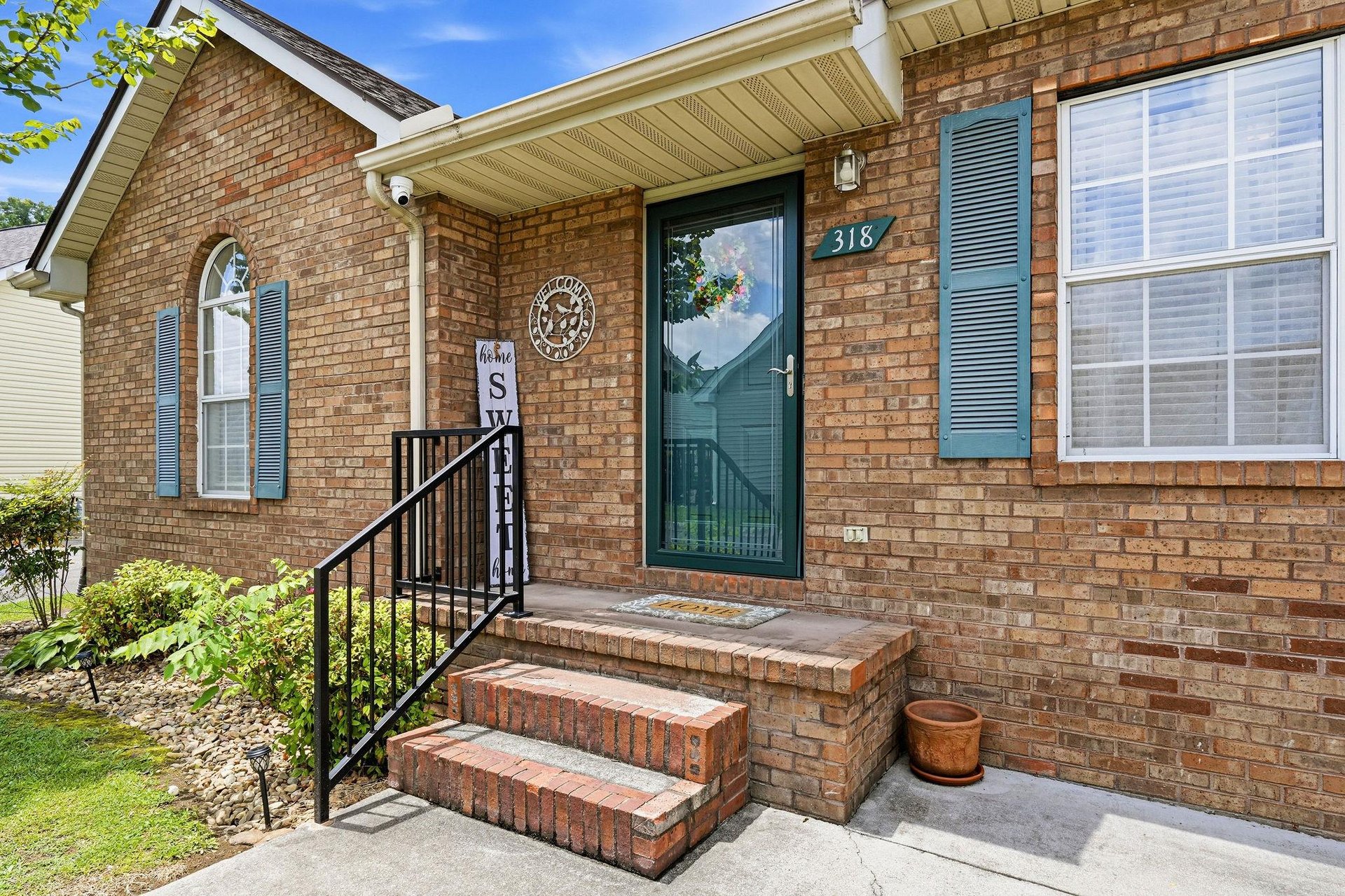 Charming brick exterior with welcoming front entrance, address number 318 clearly marked, surrounded by a wellmaintained residential neighborhood.