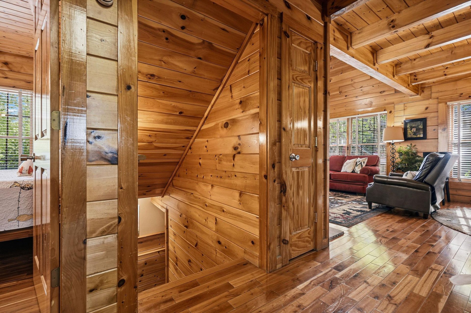 Step into your rustic retreat where warm wood surrounds you from floor to ceiling, creating a cozy mountain lodge atmosphere.