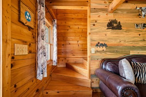 Step into your cozy cabin retreat, where warm wood walls and rustic décor create the perfect mountain escape for your stay.