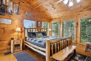 King bed with bench and several windows