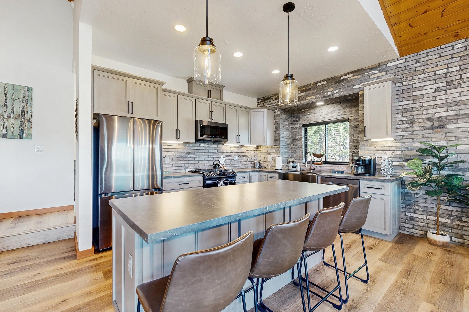 Stainless steel appliances, cooking essentials, kitchen island, and counter seating for 4 guests.