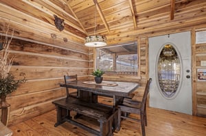 Step into rustic charm where handcrafted wood beams frame your dining moments beneath warm cabin lighting.