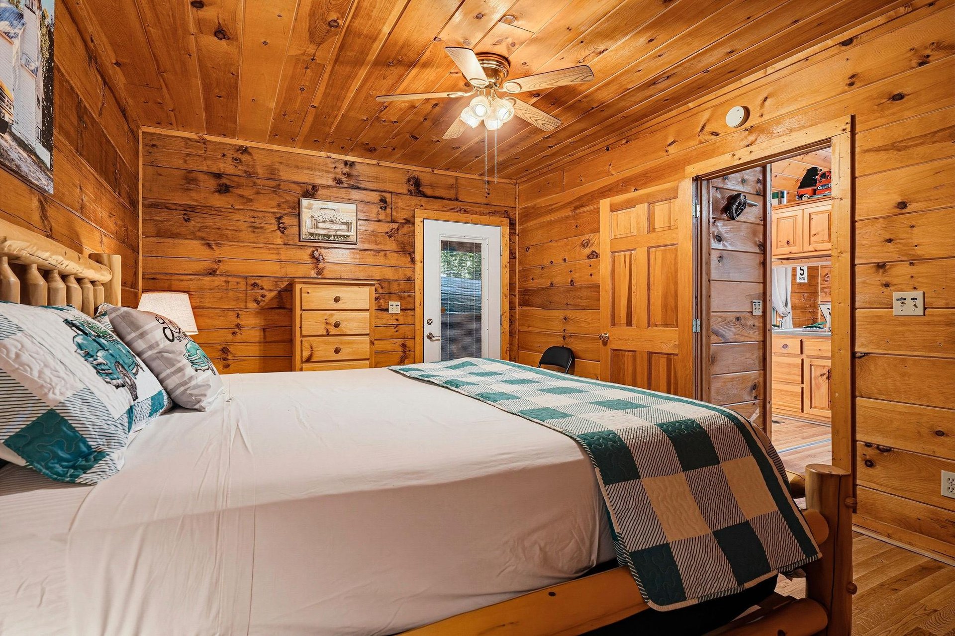 Unwind in your cozy cabin bedroom, wrapped in the warmth of natural knotty pine and soft linens, with rustic charm all around you.