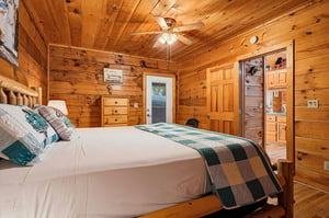 Unwind in your cozy cabin bedroom, wrapped in the warmth of natural knotty pine and soft linens, with rustic charm all around you.