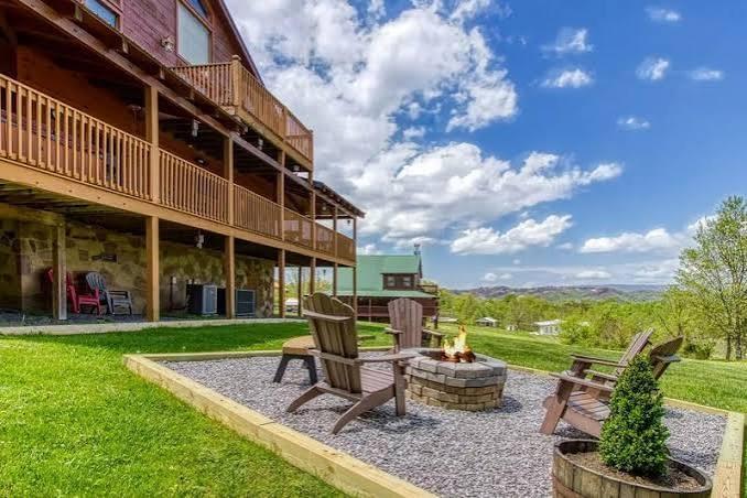 A spacious backyard retreat where rolling mountain views meet a cozy fire pit and Adirondack chairs, perfect for peaceful evenings under a wideopen sky.