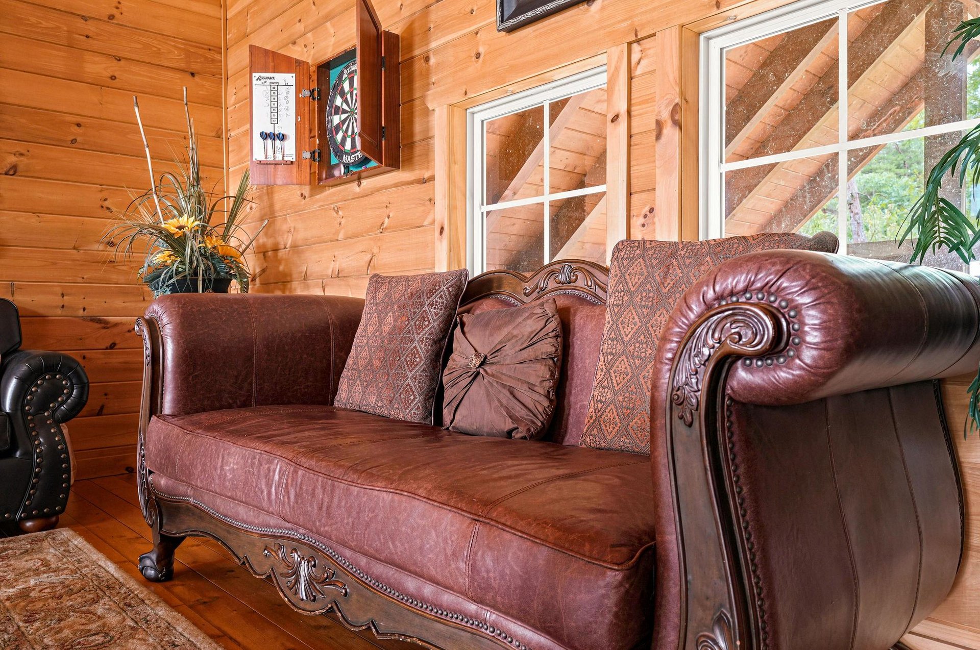 Settle into rich leather seating in your cozy living space, warmed by natural wood walls and plenty of natural light from expansive windows.