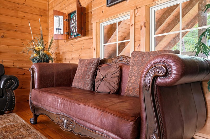 Settle into rich leather seating in your cozy living space, warmed by natural wood walls and plenty of natural light from expansive windows.