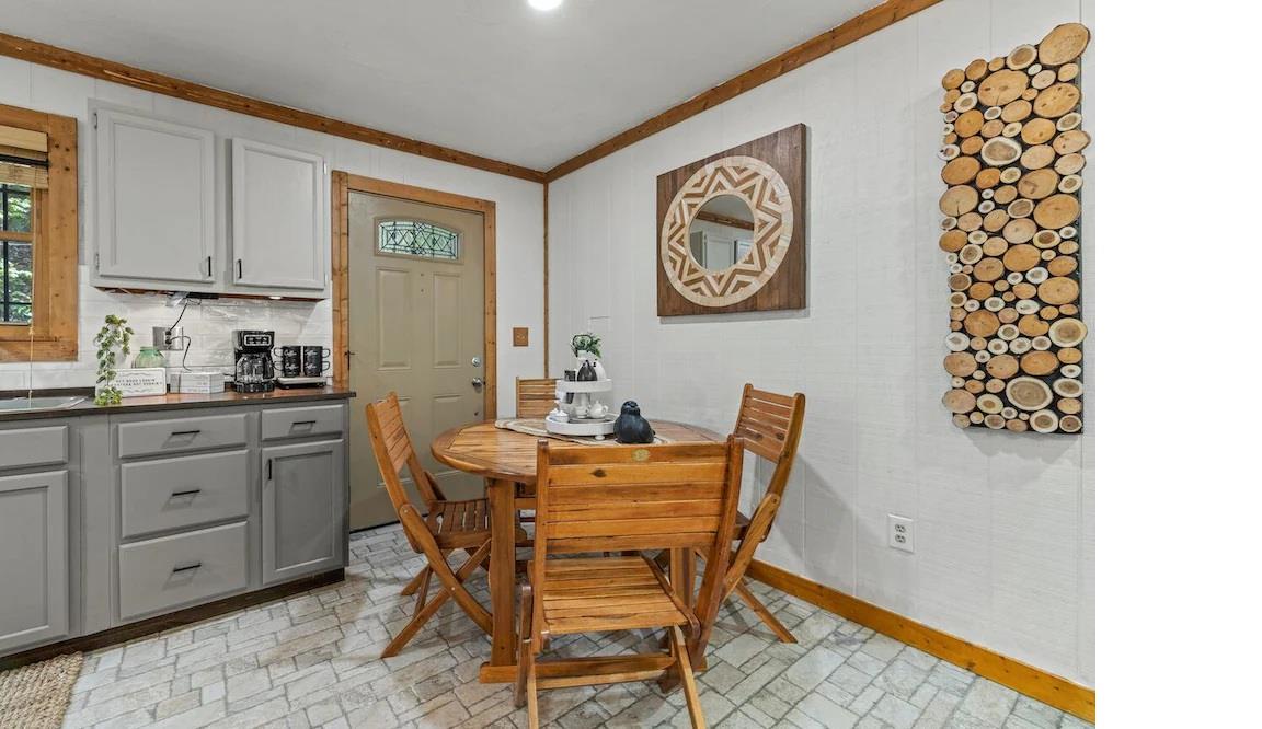 Gather around your cozy dining table in this charming kitchen space, where rustic wood beams and unique décor create the perfect spot for morning coffee.