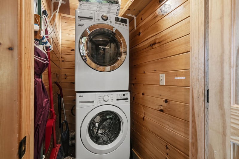 Your laundry stays fresh and effortless here with a convenient stacked washer and dryer tucked into this warm, woodpaneled space.