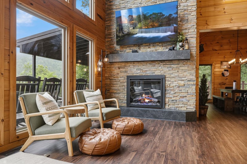 Unwind by the stone fireplace and gaze out at mountain views through towering windows. Warm wood, cozy seating, and ambient glow invite you to relax and feel right at home.