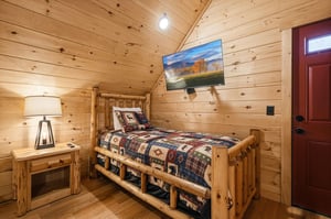 Cozy log cabin bedroom where youll drift off surrounded by warm wood walls and rustic charm, complete with your own TV for relaxing evenings.