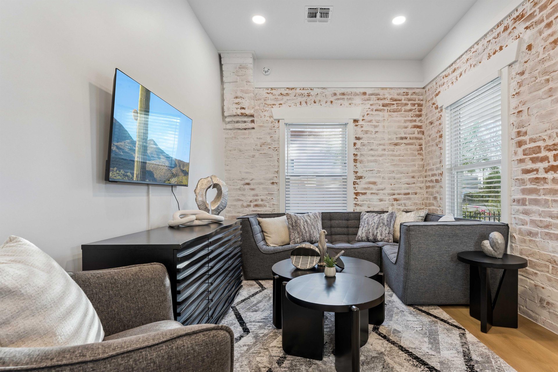 Cozy modern living room with sectional couch and flatscreen TV.