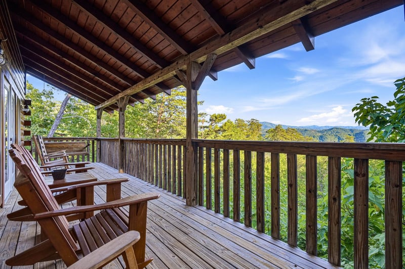 Settle into your private deck with sweeping mountain views, where peaceful mornings and golden sunsets await beneath rich wood beams and open skies.
