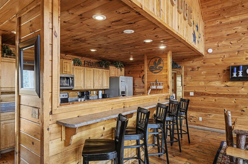 Rustic log cabin kitchen with bar seating invites you to gather and cook in mountain comfort.