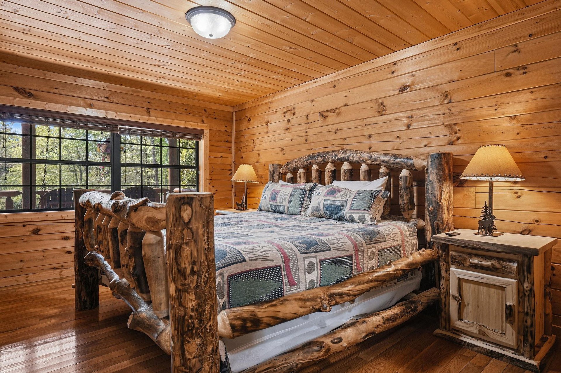 Your rustic log bedroom offers handcrafted wooden furniture and warm cabin charm, with natural light streaming through large windows for a peaceful mountain retreat.