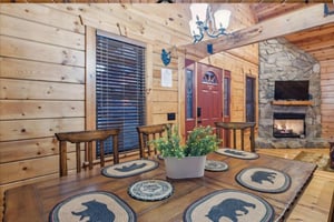 Gather around your rustic dining table where charming bear placemats await your mountain meals by the crackling fireplace.