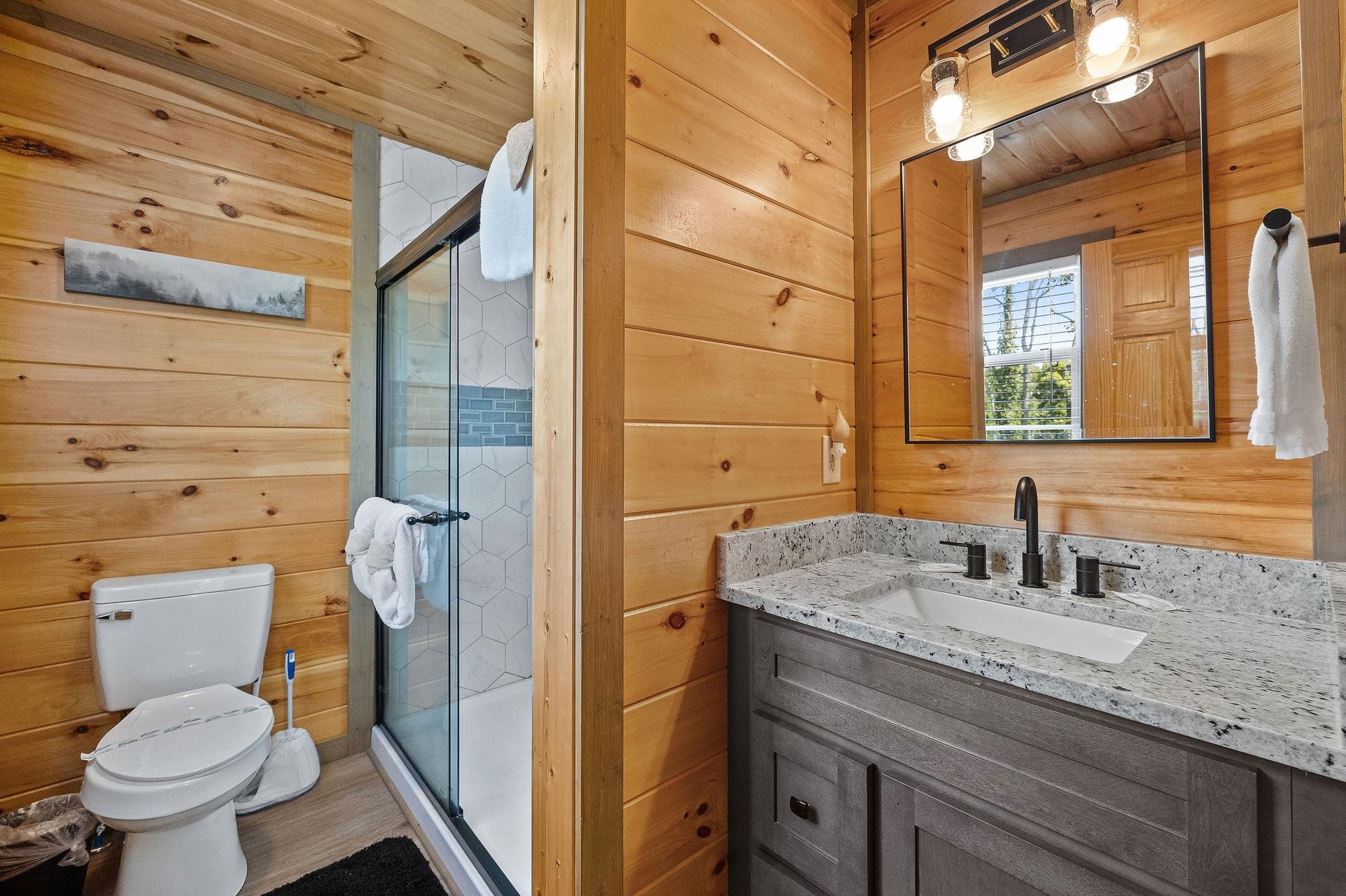 walk in tiled shower and a single vanity sink