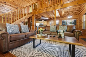 Sink into plush leather sofas surrounded by warm wood beams and rustic charm in your cozy mountain retreat.
