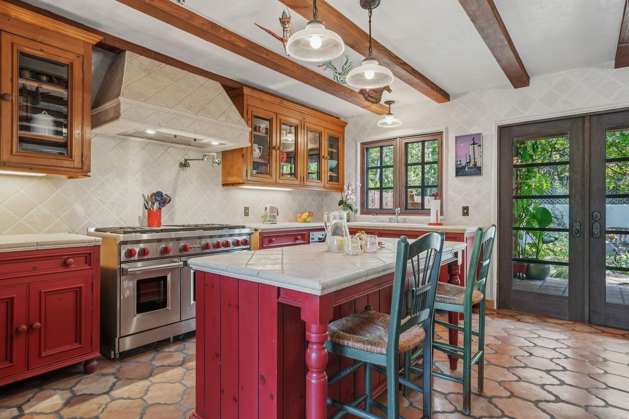 Spacious kitchen with stainless steel appliances, island with seating for 2, and cooking essentials.