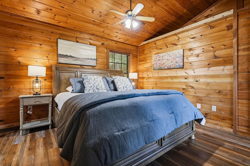 Sink into cozy comfort in this rustic bedroom with warm wood walls, soft bedding, and gentle lighting that creates the perfect retreat after your day of adventure.