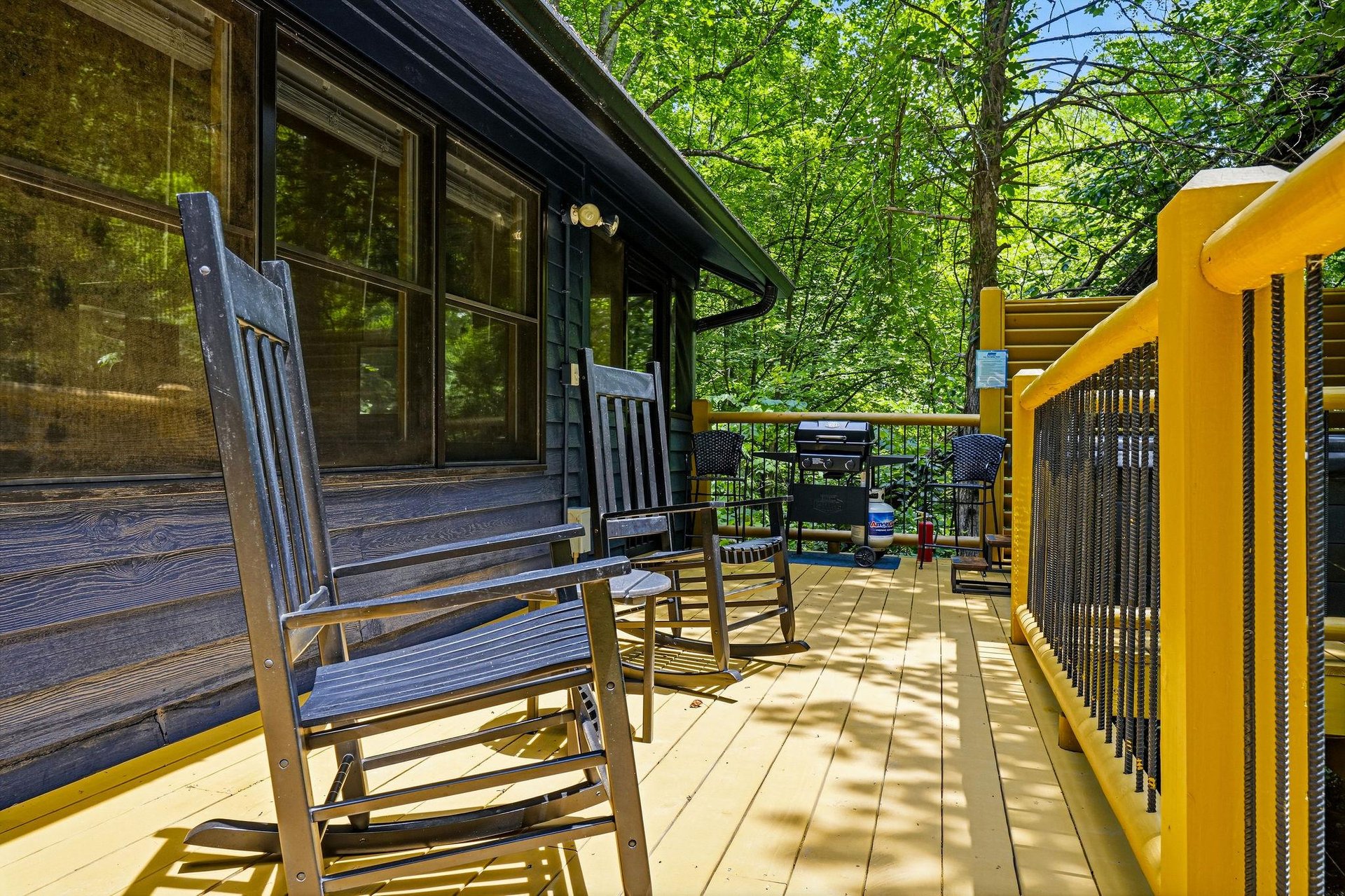 Relax on your private deck surrounded by lush greenery, where morning coffee and evening BBQs feel like a peaceful escape. The rocking chairs and shaded seating invite you to unwind.