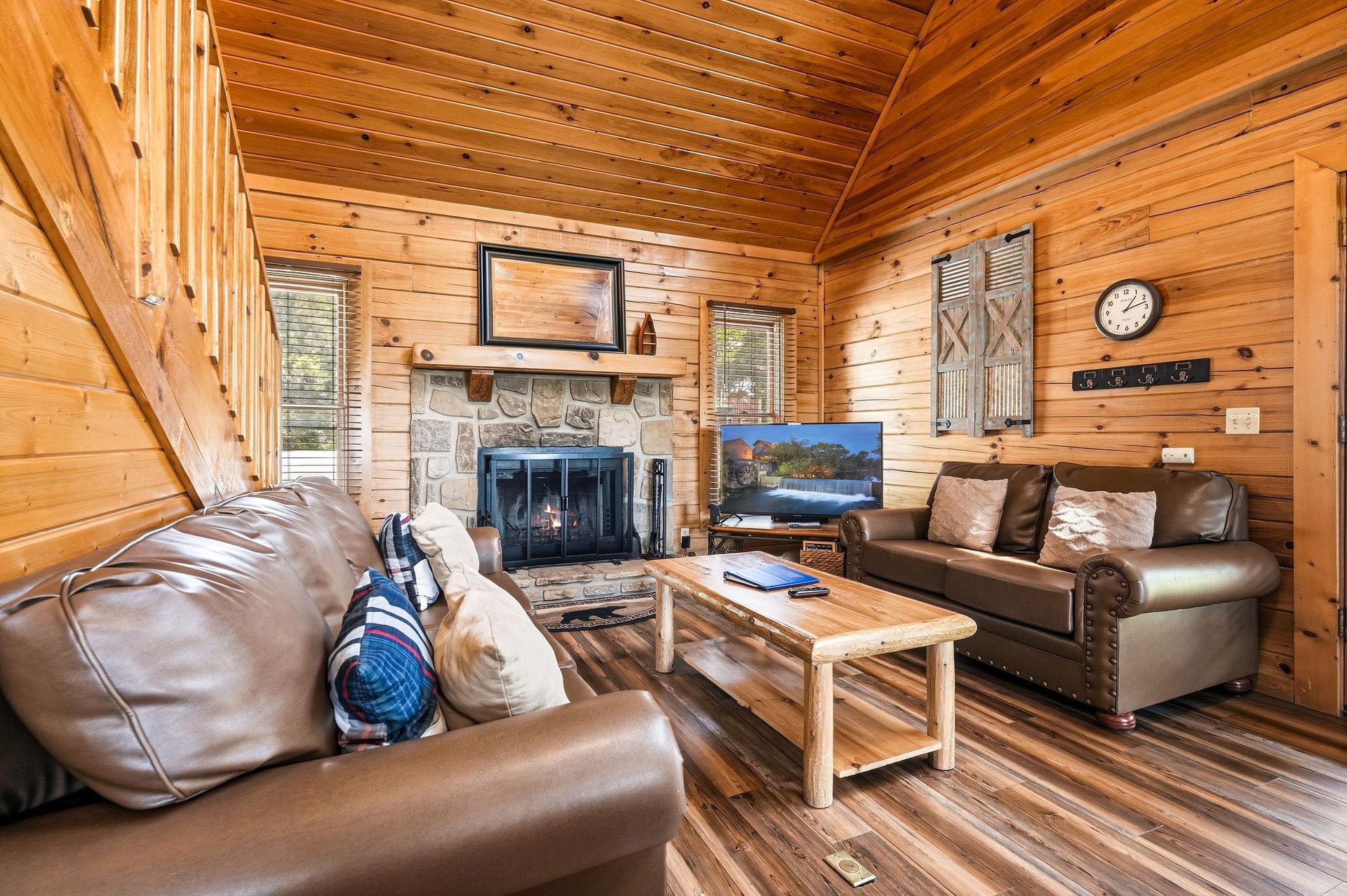 Sink into plush leather sofas in your rustic living room, where warm wood surrounds a stone fireplace—perfect for cozy evenings with your favorite shows or crackling fire.