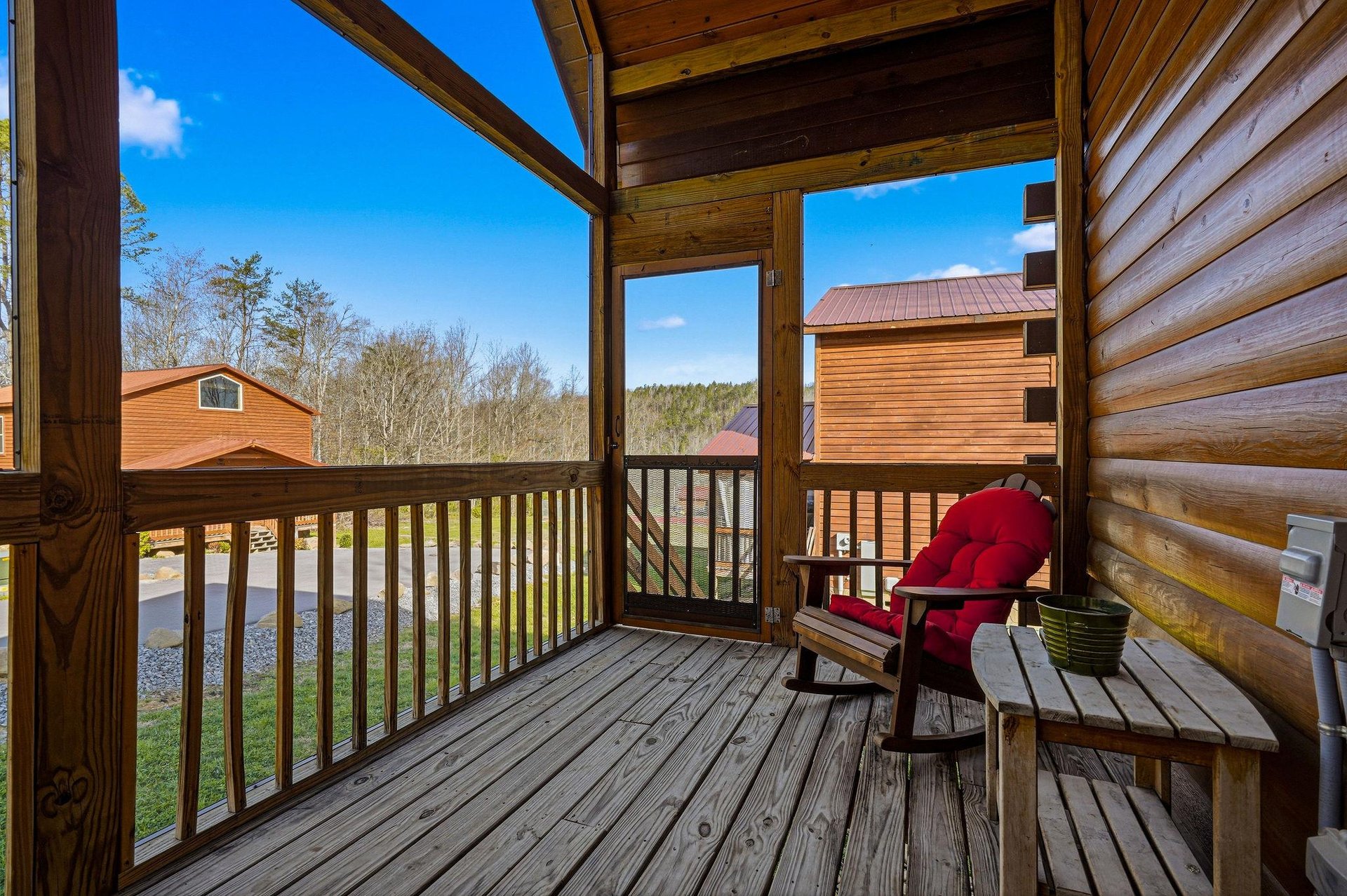 Unwind on your private covered porch with a cozy rocking chair and mountain views stretching beyond the peaceful cabin community.