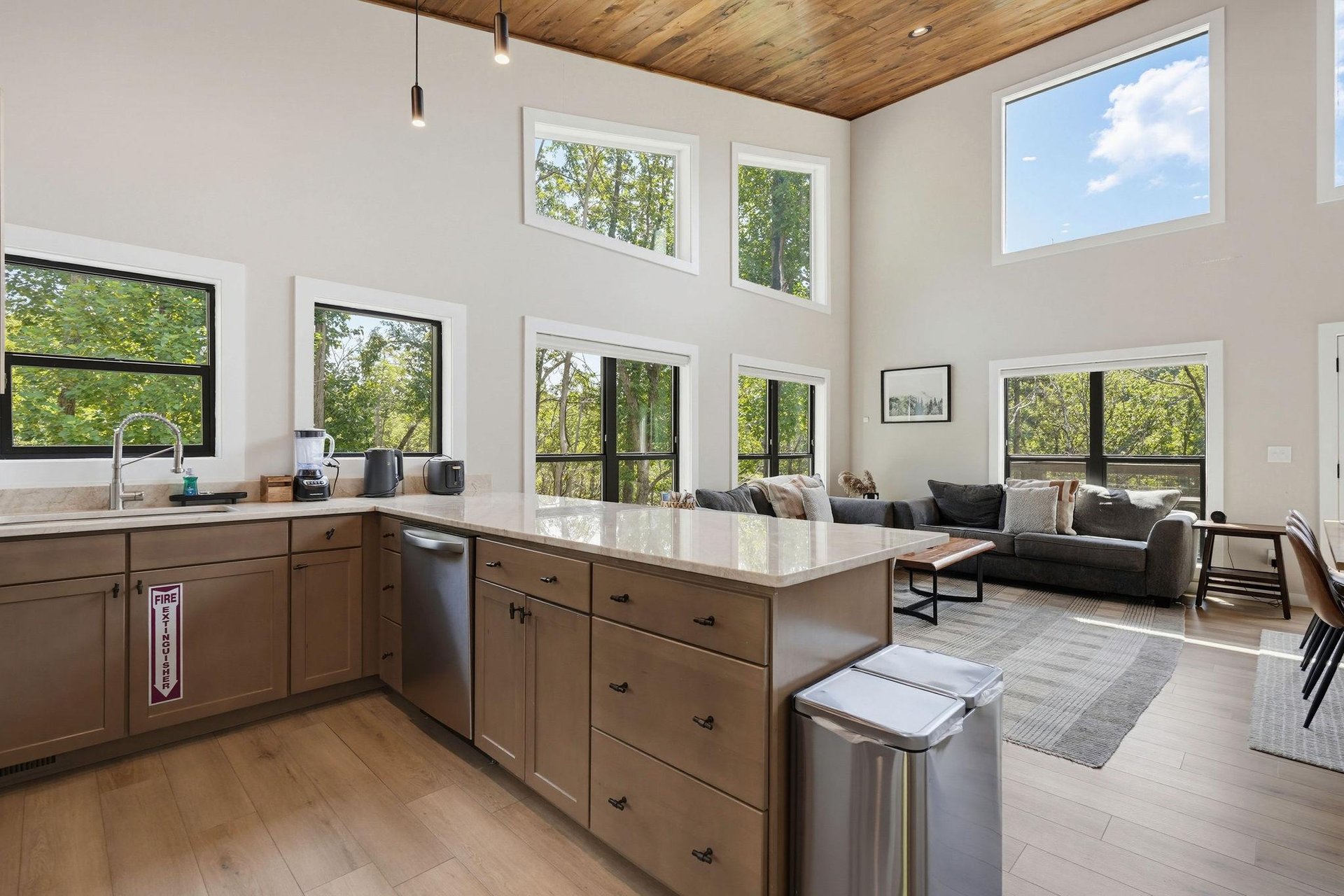 Light floods through floortoceiling windows, framing lush treetop views from your openplan kitchen and living area. High wood ceilings add warmth, while modern touches invite you to cook, relax, an