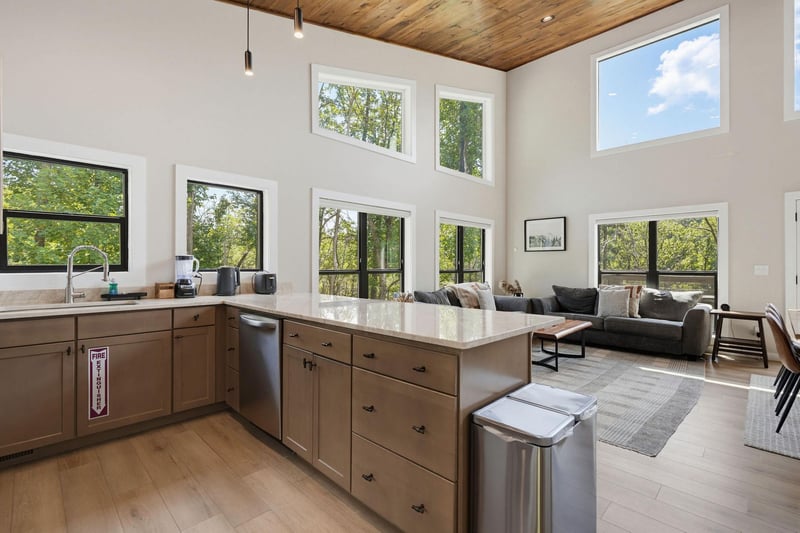 Light floods through floortoceiling windows, framing lush treetop views from your openplan kitchen and living area. High wood ceilings add warmth, while modern touches invite you to cook, relax, an