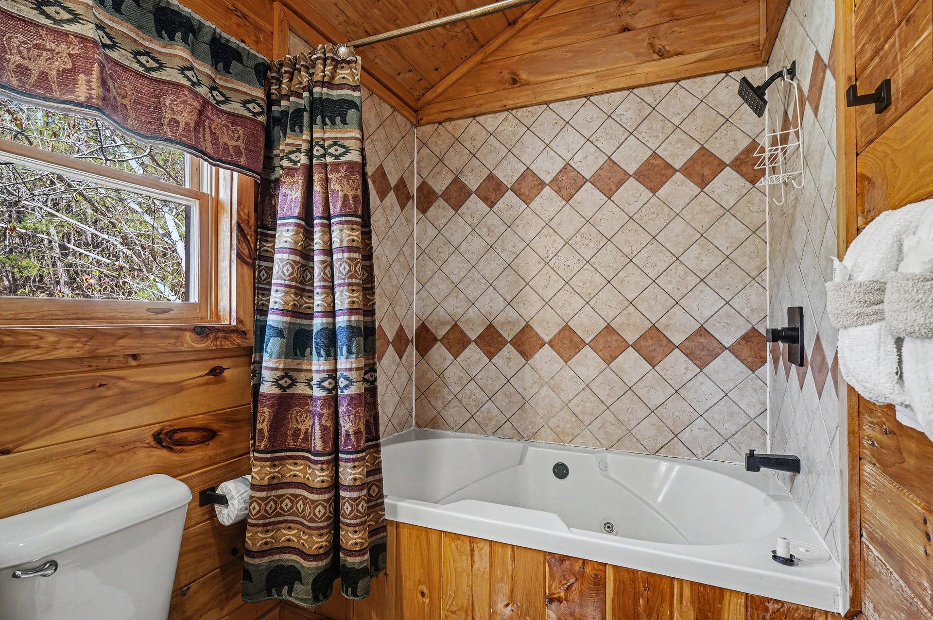 Soak in your private jetted tub surrounded by warm wood paneling and charming rustic details that make every bath feel like a woodland retreat.