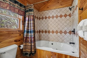 Soak in your private jetted tub surrounded by warm wood paneling and charming rustic details that make every bath feel like a woodland retreat.