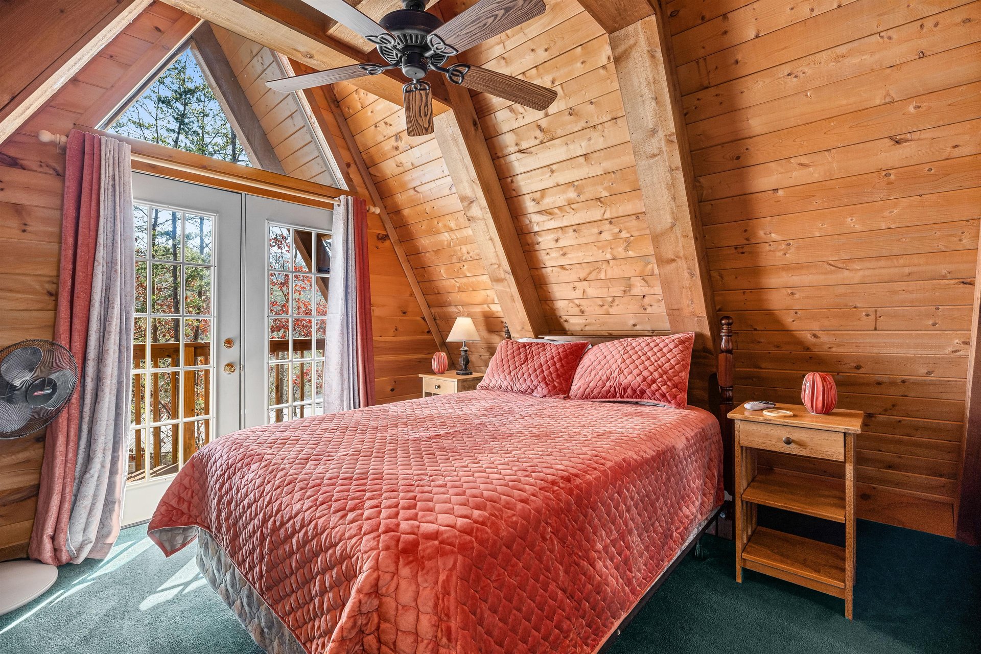 Bedroom with night stands, lamps, and deck access at Living on Love, a 2 bedroom cabin rental located in Pigeon Forge