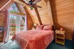Bedroom with night stands, lamps, and deck access at Living on Love, a 2 bedroom cabin rental located in Pigeon Forge