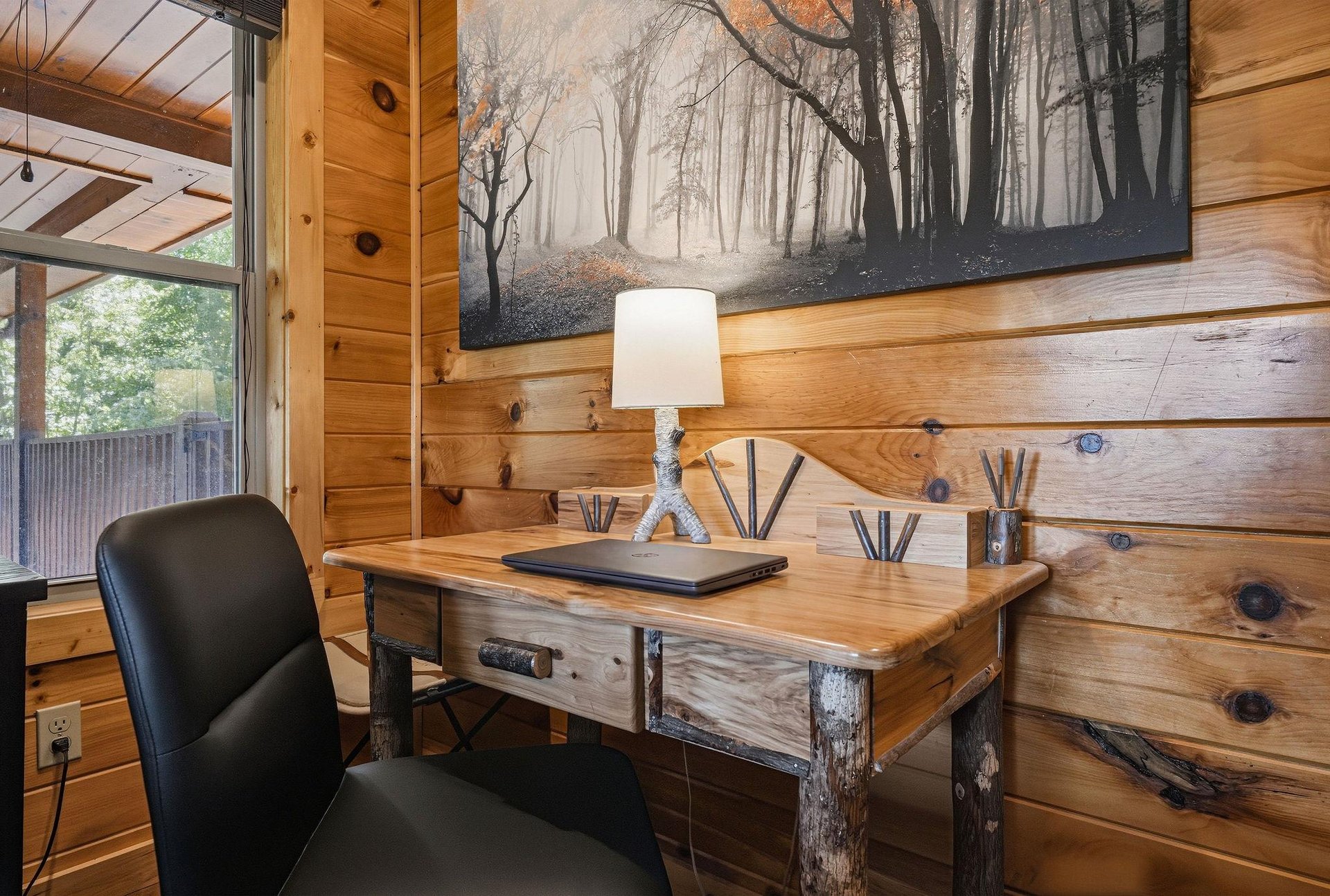 Settle into your rustic workspace, where warm wood walls and natural light create the perfect blend of comfort and productivity for your getaway.