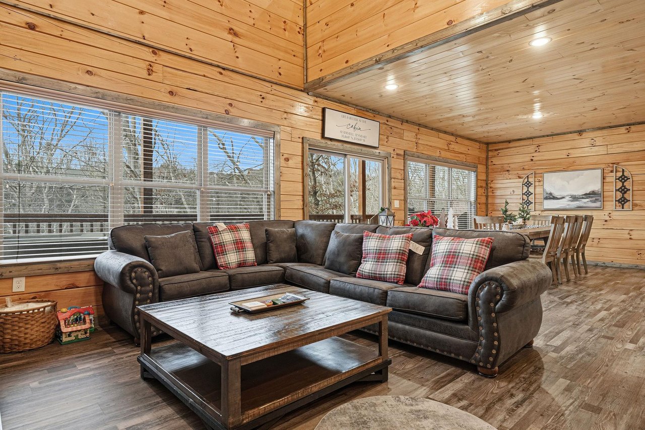 Relax in your spacious living room with a plush leather sectional and rustic wood accents creating the perfect cozy mountain retreat.