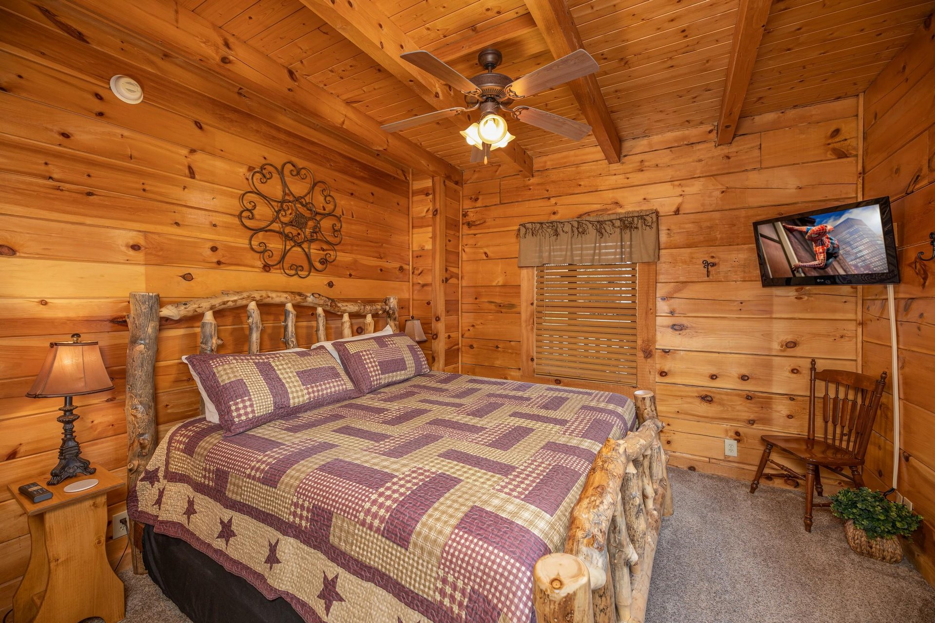 Bedroom with bed, night stands, lamps, and TV at Livin Simple, a 2 bedroom cabin rental located in Pigeon Forge