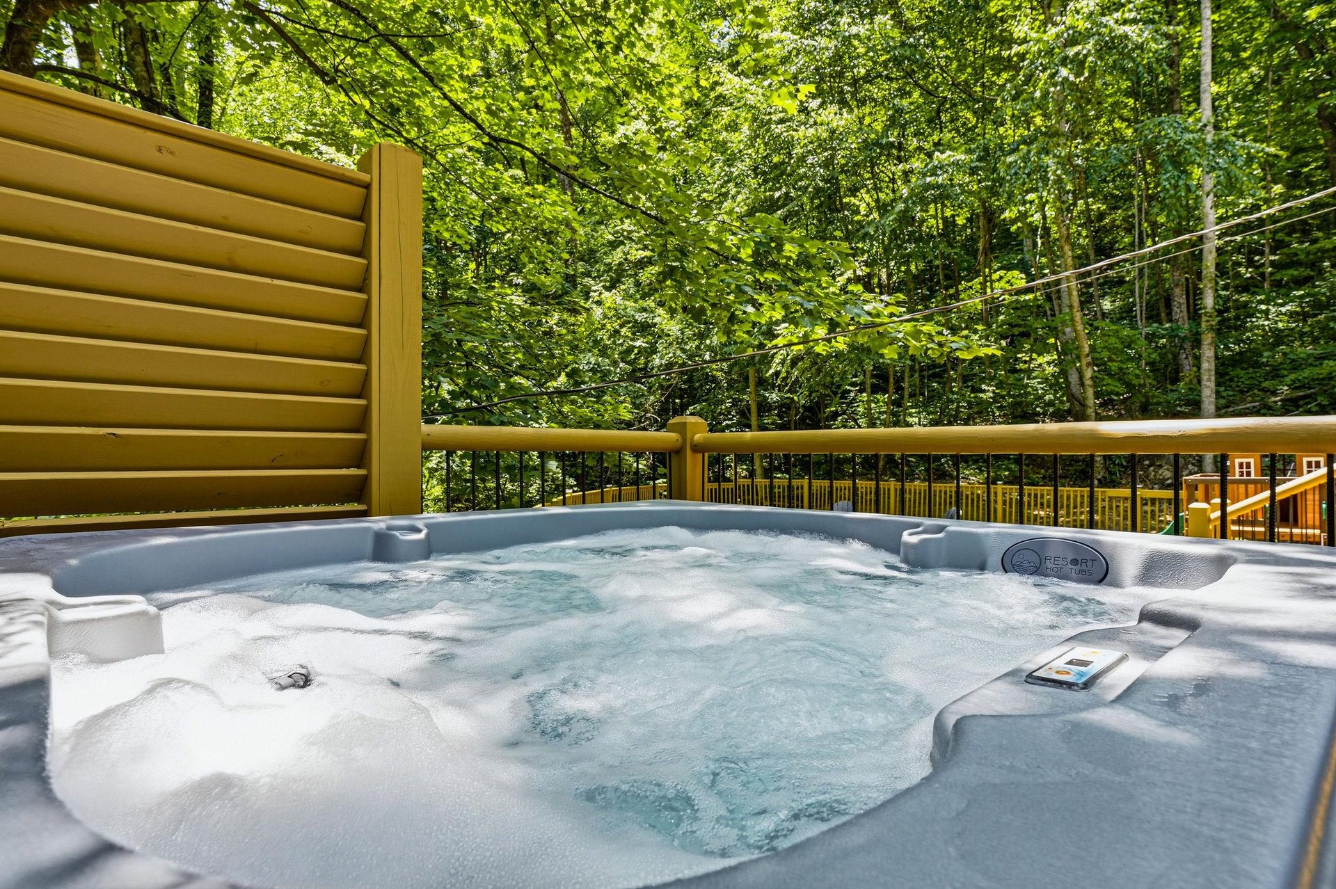 A private hot tub surrounded by lush forest greenery offers the perfect spot to unwind after your adventures, with the gentle sounds of nature all around you.