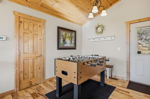 Challenge friends to exciting foosball matches in your dedicated game room with rustic wood beams and cozy mountain lodge charm.