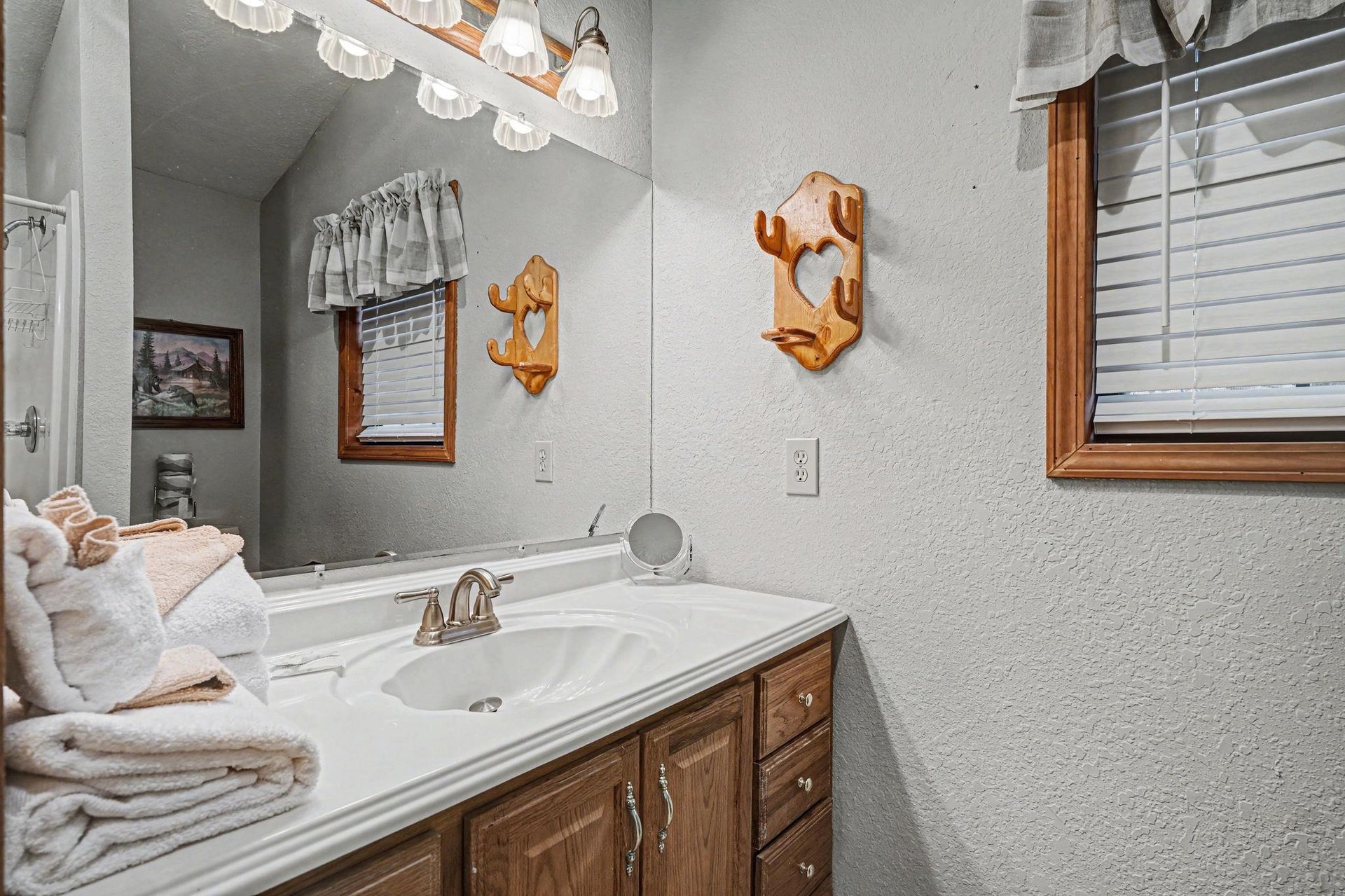 Freshen up in your charming bathroom with warm wood accents, soft lighting, and fluffy towels waiting for your arrival.