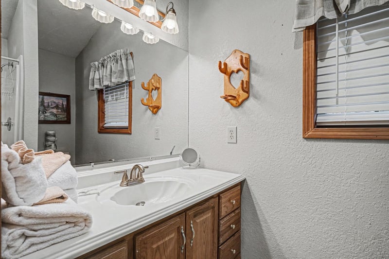 Freshen up in your charming bathroom with warm wood accents, soft lighting, and fluffy towels waiting for your arrival.