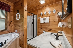 Step into your cabins warm pine bathroom, complete with double sinks, a spacious shower, and charming rustic details that make you feel right at home.