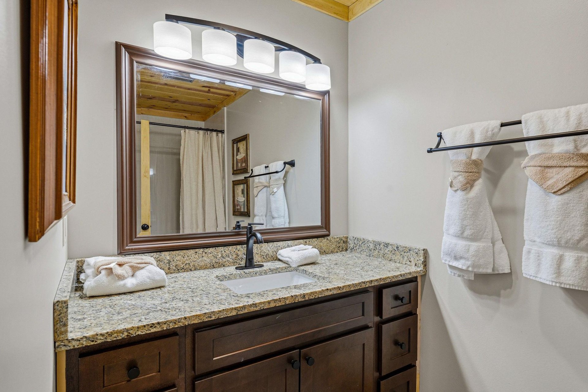 Step into your private bathroom, where crisp towels and a welcoming vanity await your arrival. Warm wood tones and soft lighting create a cozy retreat for your mountain getaway.
