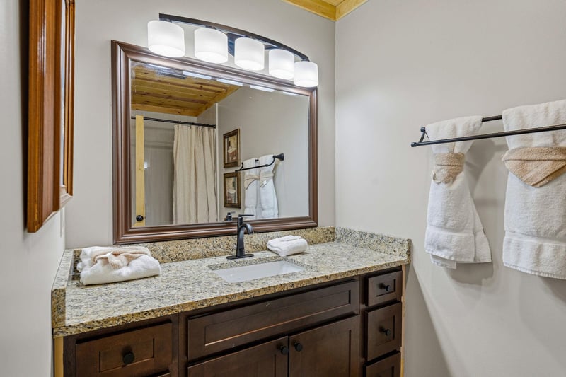Step into your private bathroom, where crisp towels and a welcoming vanity await your arrival. Warm wood tones and soft lighting create a cozy retreat for your mountain getaway.