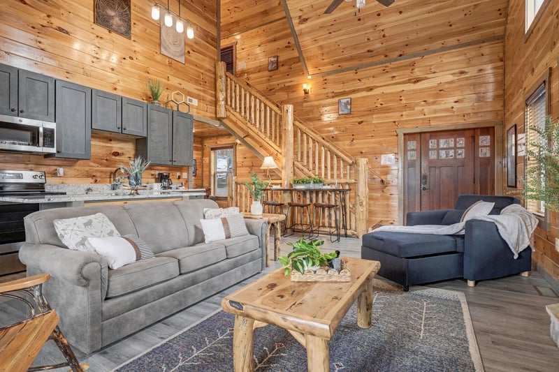 Sink into plush sofas surrounded by warm wood walls, where rustic charm meets modern comfort in your cozy mountain retreat.